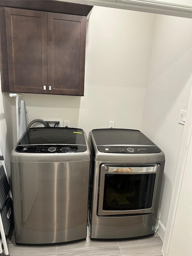 311 Eado Park Cir, Houston, TX 77020 - laundry room with cabinet space, separate washer and dryer, and light wood-type flooring