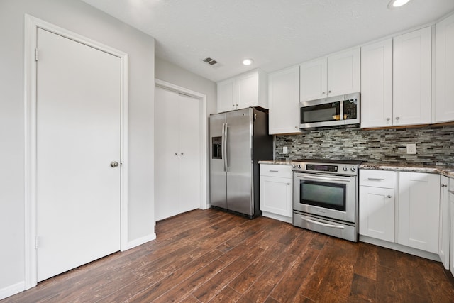 3518 Grove Oaks Dr, Houston, TX 77339 - kitchen featuring appliances with stainless steel finishes, dark wood finished floors, stone countertops, tasteful backsplash, and white cabinetry