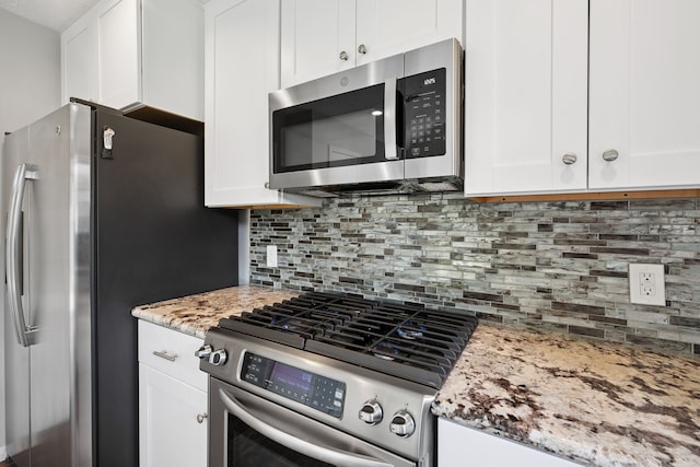 3518 Grove Oaks Dr, Houston, TX 77339 - kitchen featuring stainless steel appliances, white cabinets, tasteful backsplash, and light stone countertops
