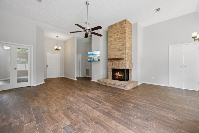 3518 Grove Oaks Dr, Houston, TX 77339 - unfurnished living room featuring wood finished floors, a ceiling fan, high vaulted ceiling, a brick fireplace, and a chandelier