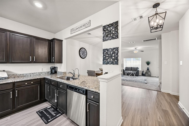 11034 Hillside Creek Dr, Humble, TX 77396 - kitchen with stainless steel dishwasher, light wood finished floors, a peninsula, light stone counters, and a chandelier