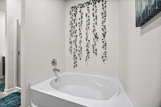 11034 Hillside Creek Dr, Humble, TX 77396 - full bath featuring a garden tub and a textured wall