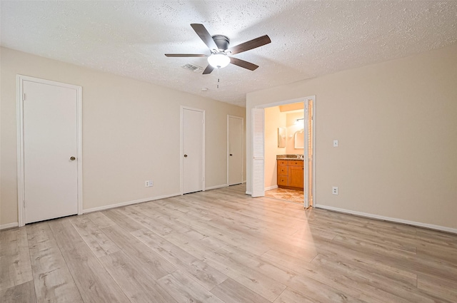 13506 Sherwood St, Sugar Land, TX 77498 - unfurnished bedroom with light wood-style floors, a textured ceiling, connected bathroom, two closets, and a ceiling fan