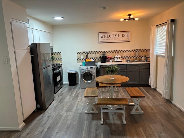 1529 Wirt Rd Unit 6, Houston, TX 77055 - kitchen with washer / dryer, stainless steel appliances, tasteful backsplash, and wood finished floors
