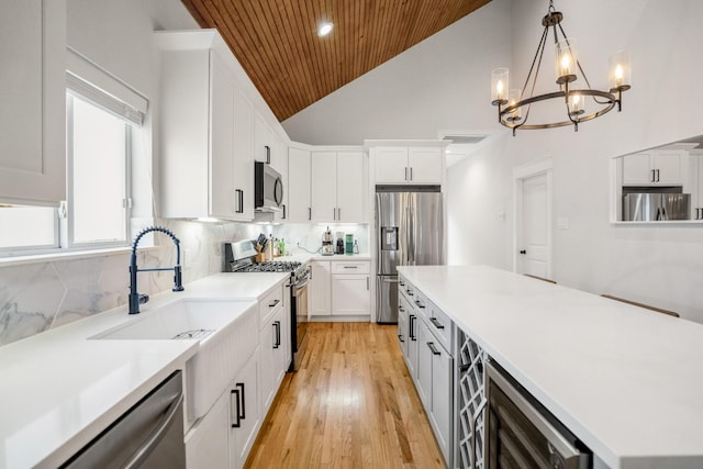 703 Dumble St, Houston, TX 77023 - kitchen featuring appliances with stainless steel finishes, wooden ceiling, white cabinets, a center island, and light countertops