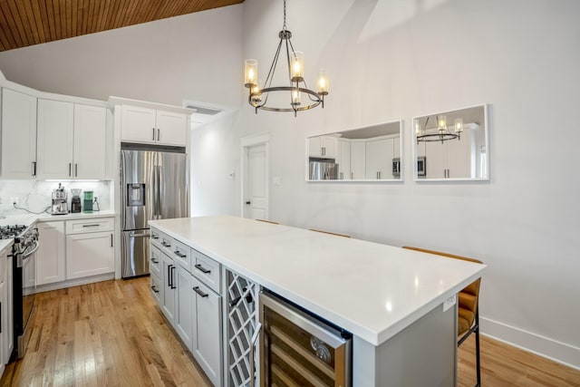 703 Dumble St, Houston, TX 77023 - kitchen with appliances with stainless steel finishes, wine cooler, a chandelier, wood ceiling, and light countertops