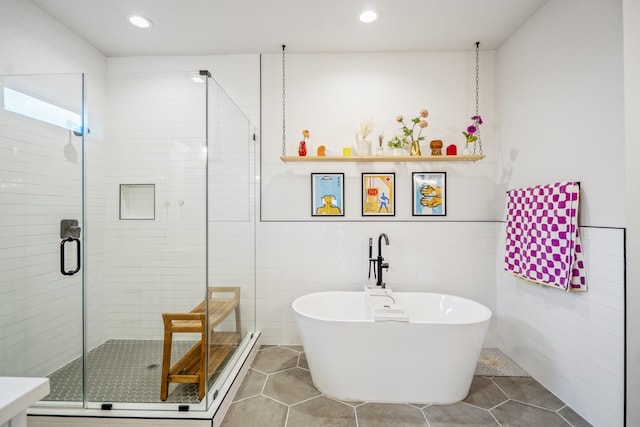 703 Dumble St, Houston, TX 77023 - full bath with a soaking tub, a stall shower, tile patterned flooring, recessed lighting, and tile walls