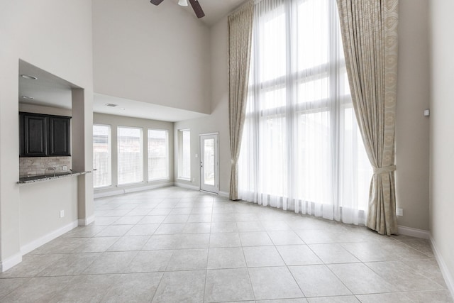 2131 Blossomcrown Dr, Katy, TX 77494 - unfurnished living room with ceiling fan, light tile patterned flooring, and a high ceiling