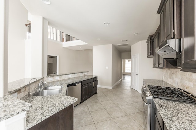 2131 Blossomcrown Dr, Katy, TX 77494 - kitchen with appliances with stainless steel finishes, tasteful backsplash, light tile patterned floors, dark brown cabinets, and extractor fan