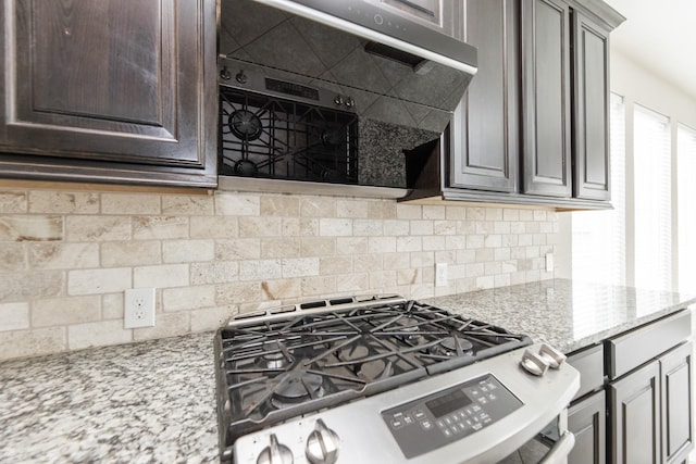 2131 Blossomcrown Dr, Katy, TX 77494 - kitchen featuring gas range, decorative backsplash, dark brown cabinets, light stone countertops, and extractor fan