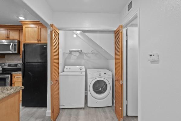 9005 Imogene St Unit C, Houston, TX 77036 - laundry room featuring washer and clothes dryer and light wood finished floors