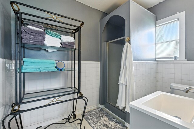 619 10th St, Hempstead, TX 77445 - full bathroom with tile walls, an enclosed shower, and a wainscoted wall