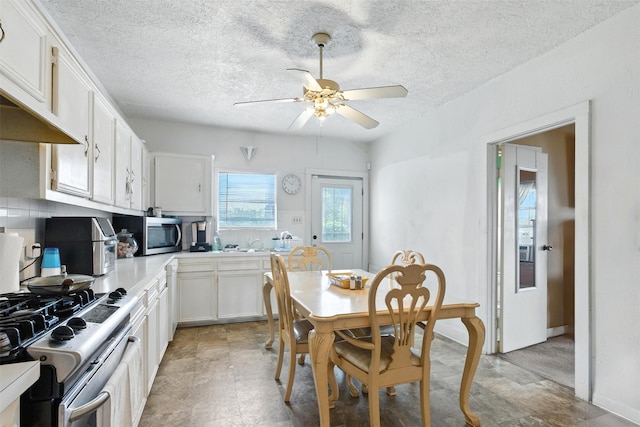 619 10th St, Hempstead, TX 77445 - kitchen with stainless steel appliances, a ceiling fan, custom range hood, white cabinetry, and a textured ceiling