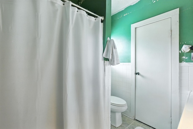 619 10th St, Hempstead, TX 77445 - bathroom with tile walls, a wainscoted wall, tile patterned flooring, and a shower with shower curtain