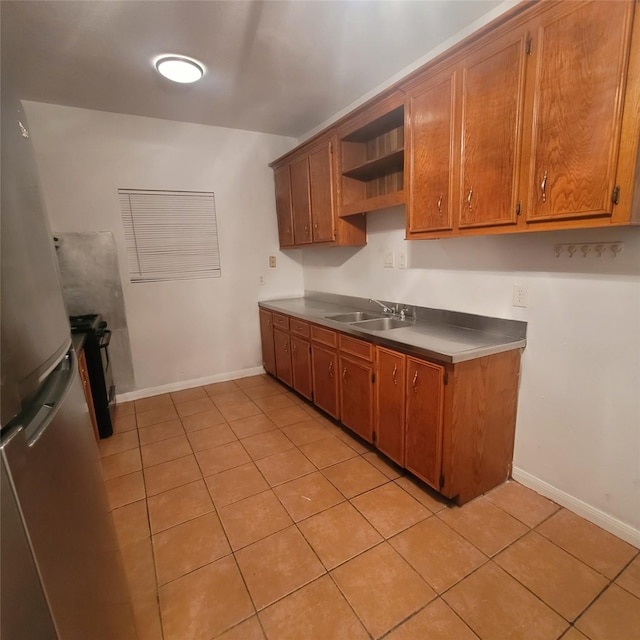 1814 Gano St, Houston, TX 77009 - kitchen featuring light tile patterned flooring, freestanding refrigerator, open shelves, and brown cabinets