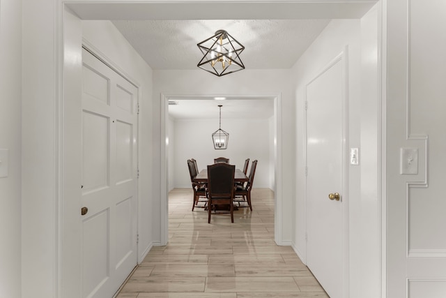 2811 Blue Glen Ln, Houston, TX 77073 - hallway with a chandelier, a textured ceiling, and light wood-style floors