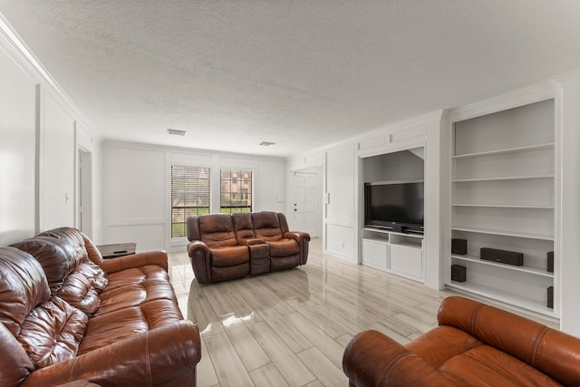 2811 Blue Glen Ln, Houston, TX 77073 - living area featuring crown molding, built in features, a textured ceiling, a decorative wall, and light wood-style flooring