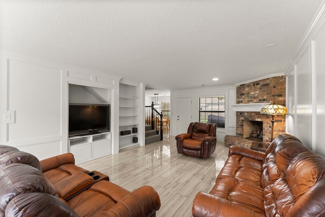 2811 Blue Glen Ln, Houston, TX 77073 - living room featuring stairs, built in features, a textured ceiling, a brick fireplace, and crown molding