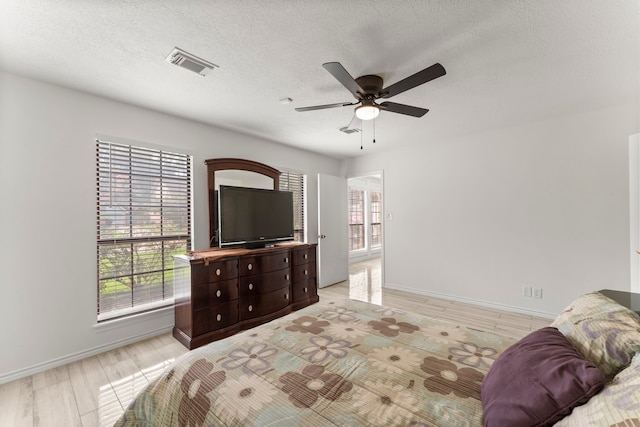 2811 Blue Glen Ln, Houston, TX 77073 - bedroom with a textured ceiling, ceiling fan, and light wood finished floors