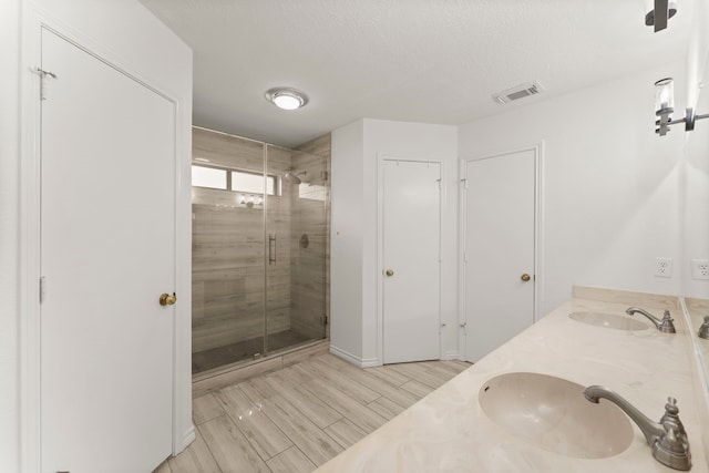 2811 Blue Glen Ln, Houston, TX 77073 - full bath featuring a shower stall, double vanity, wood finished floors, and a textured ceiling