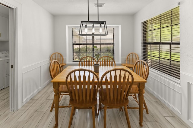 2811 Blue Glen Ln, Houston, TX 77073 - dining room featuring a decorative wall, wood finish floors, wainscoting, and washer / clothes dryer