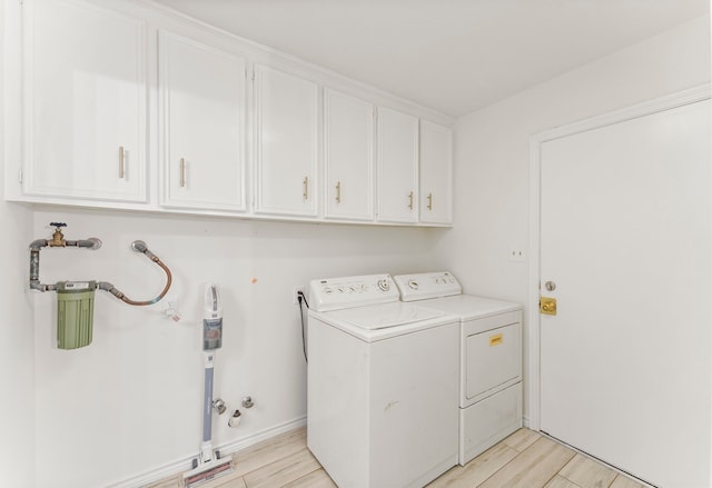 2811 Blue Glen Ln, Houston, TX 77073 - washroom featuring washing machine and clothes dryer, cabinet space, and light wood-style floors