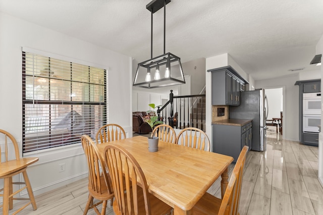 2811 Blue Glen Ln, Houston, TX 77073 - dining area with stairs, wood tiled floors, and a textured ceiling