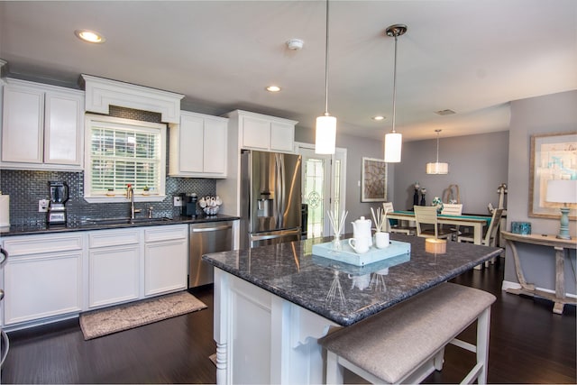 150 Edgewater Way, Point Blank, TX 77364 - kitchen featuring stainless steel appliances, dark wood-type flooring, white cabinets, tasteful backsplash, and a breakfast bar