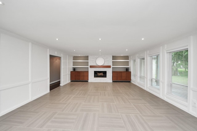 606 Montclair Blvd, Sugar Land, TX 77478 - unfurnished living room featuring built in features, ornamental molding, a large fireplace, recessed lighting, and a decorative wall