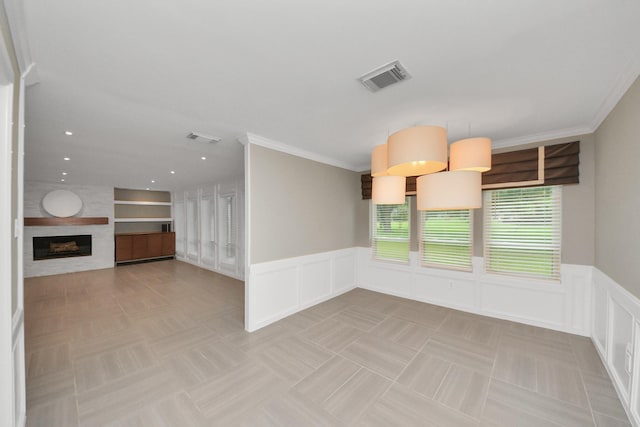 606 Montclair Blvd, Sugar Land, TX 77478 - empty room featuring a decorative wall, wainscoting, a fireplace, built in shelves, and crown molding