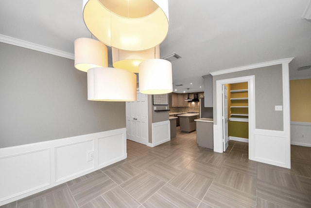 606 Montclair Blvd, Sugar Land, TX 77478 - kitchen featuring crown molding, wainscoting, light countertops, tasteful backsplash, and a decorative wall