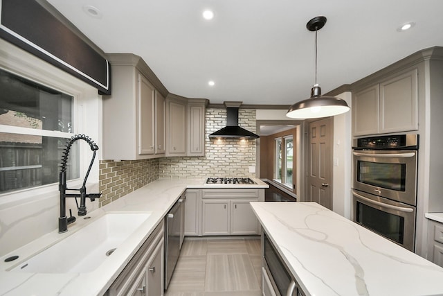606 Montclair Blvd, Sugar Land, TX 77478 - kitchen with stainless steel appliances, wall chimney exhaust hood, gray cabinetry, tasteful backsplash, and decorative light fixtures