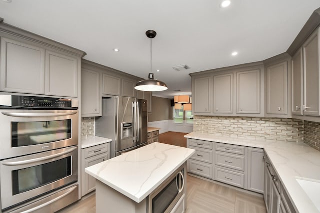 606 Montclair Blvd, Sugar Land, TX 77478 - kitchen featuring appliances with stainless steel finishes, gray cabinets, a warming drawer, recessed lighting, and decorative backsplash