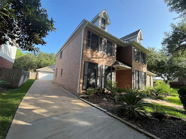 17427 Marigold Dr, Sugar Land, TX 77479 - view of property exterior with brick siding, a detached garage, and an outdoor structure