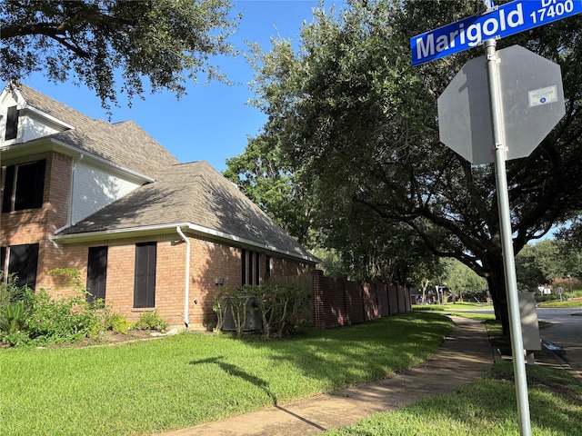 17427 Marigold Dr, Sugar Land, TX 77479 - view of property exterior featuring brick siding, a lawn, and roof with shingles