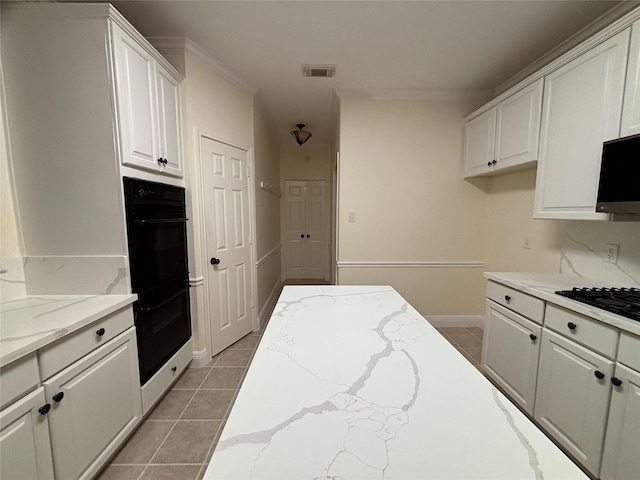 17427 Marigold Dr, Sugar Land, TX 77479 - kitchen with black appliances, white cabinets, light stone countertops, and light tile patterned flooring