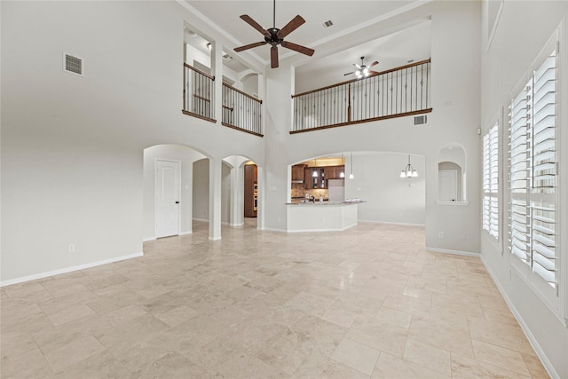 3102 Hillside Landing Trl, Katy, TX 77494 - unfurnished living room with a ceiling fan, plenty of natural light, arched walkways, a high ceiling, and ornamental molding