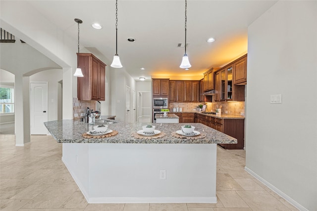 3102 Hillside Landing Trl, Katy, TX 77494 - kitchen featuring stainless steel appliances, a peninsula, arched walkways, tasteful backsplash, and light stone countertops