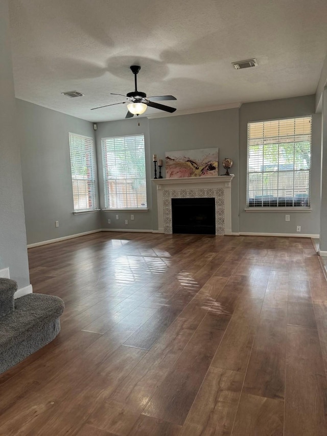 7923 Harvester St, Houston, TX 77095 - unfurnished living room featuring plenty of natural light, ceiling fan, wood finished floors, a tile fireplace, and a textured ceiling