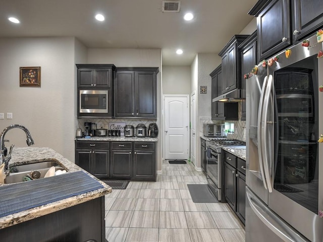 6127 Rosehill Harvest Loop, Katy, TX 77493 - kitchen with stainless steel appliances, tasteful backsplash, light stone countertops, recessed lighting, and light tile patterned flooring