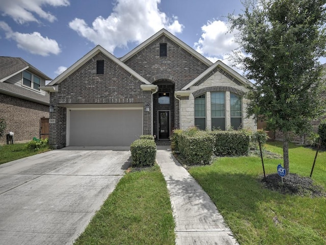 6127 Rosehill Harvest Loop, Katy, TX 77493 - french provincial home featuring an attached garage, a front lawn, concrete driveway, stone siding, and brick siding