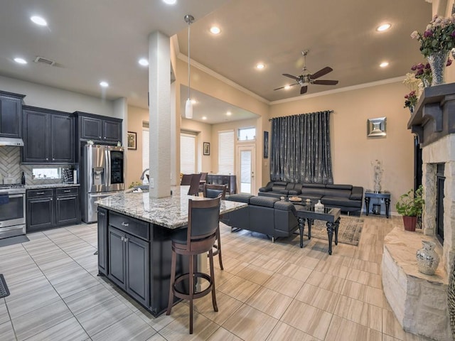 6127 Rosehill Harvest Loop, Katy, TX 77493 - kitchen featuring stainless steel appliances, a ceiling fan, open floor plan, a breakfast bar area, and backsplash