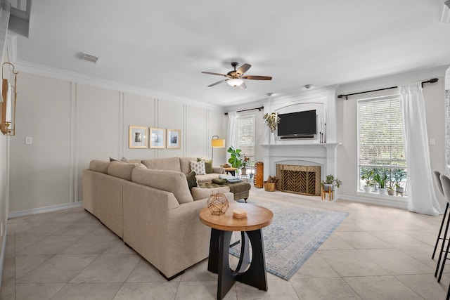 2413 Sawgrass Ct, League City, TX 77573 - living room featuring a ceiling fan, plenty of natural light, a fireplace, light tile patterned floors, and crown molding