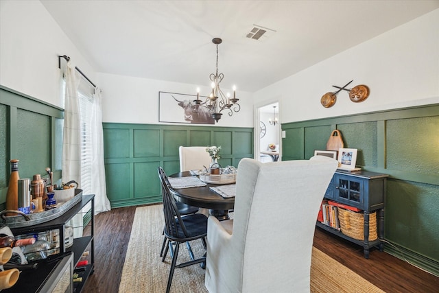 12502 Nova Dr, Houston, TX 77077 - dining space with a chandelier, a decorative wall, a wainscoted wall, and dark wood-style flooring