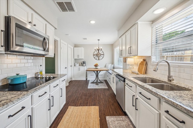 12502 Nova Dr, Houston, TX 77077 - kitchen featuring appliances with stainless steel finishes, dark wood-type flooring, white cabinets, backsplash, and recessed lighting