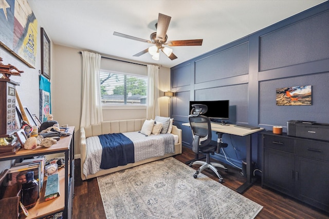 12502 Nova Dr, Houston, TX 77077 - bedroom with a decorative wall, an office area, dark wood-style flooring, and a ceiling fan