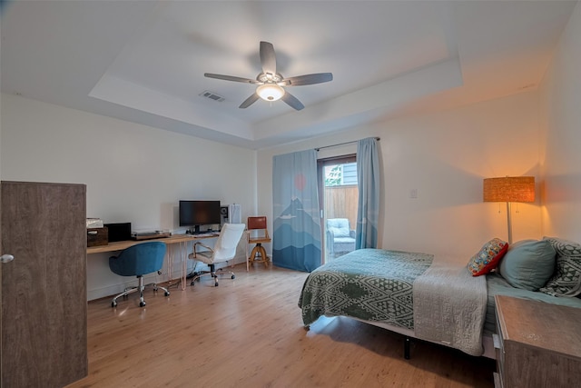 308 Dennis St, Houston, TX 77006 - bedroom with a raised ceiling, a desk, wood finished floors, a ceiling fan, and access to exterior