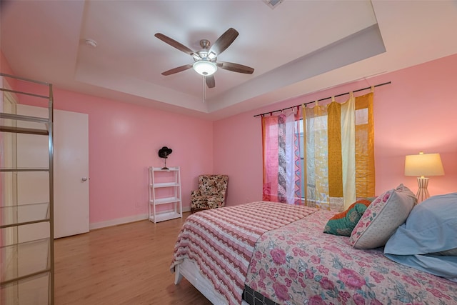 308 Dennis St, Houston, TX 77006 - bedroom featuring a tray ceiling, wood finished floors, and a ceiling fan