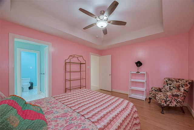 308 Dennis St, Houston, TX 77006 - bedroom featuring a raised ceiling, wood finished floors, a ceiling fan, and ensuite bath