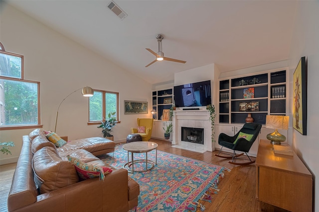 308 Dennis St, Houston, TX 77006 - living room with a ceiling fan, wood finished floors, a tile fireplace, and high vaulted ceiling